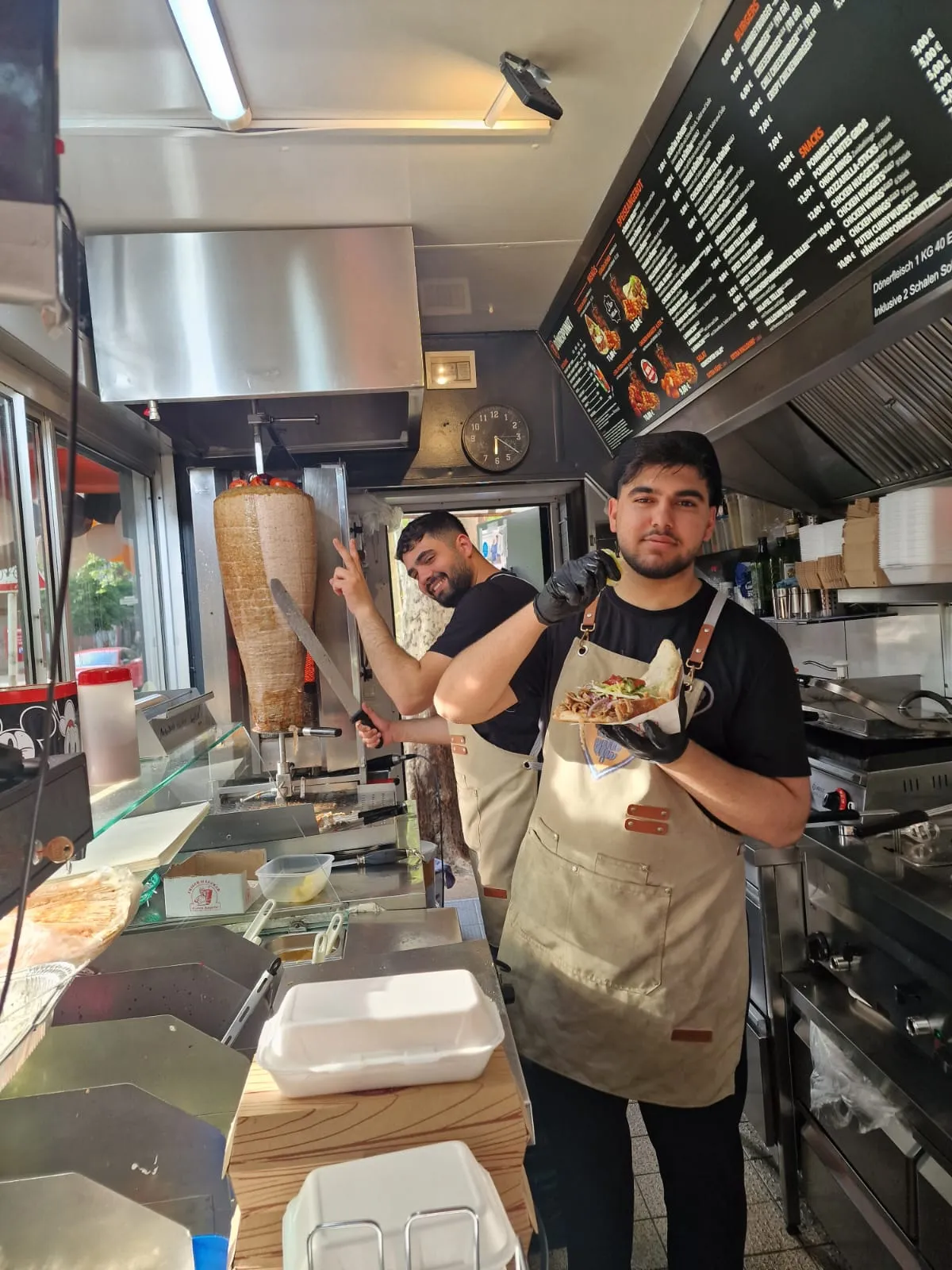 Das Dönerpunkt-Team hinter der Theke, vorne ein frisch belegter Döner, hinten am Spieß